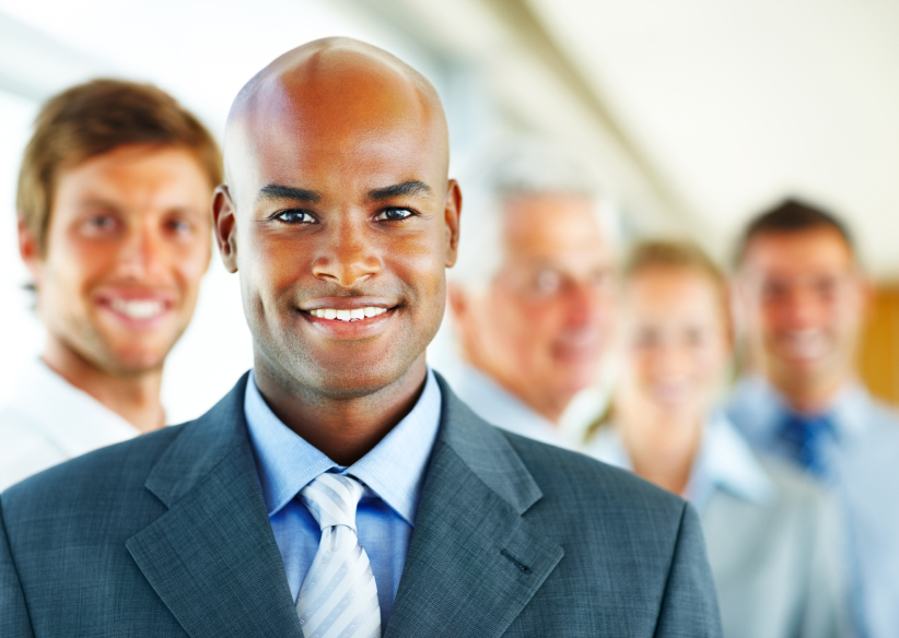 Young business man with his business colleagues at his back