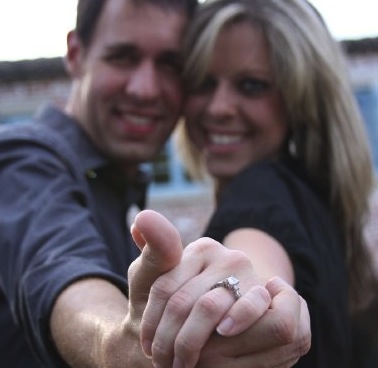 smiling couple looking at engagement ring