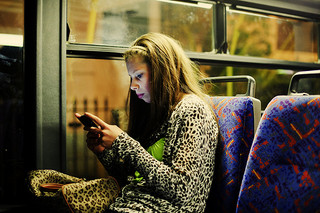 girl on phone on public transportation