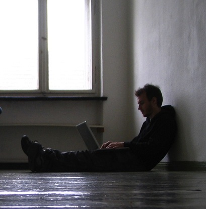 teen sitting on floor looking at computer