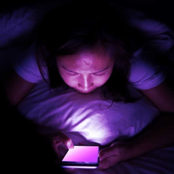 woman reading phone in bed