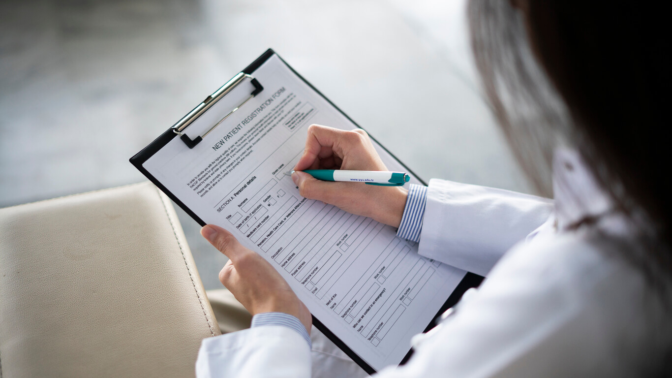 A doctor filling out a patient form.