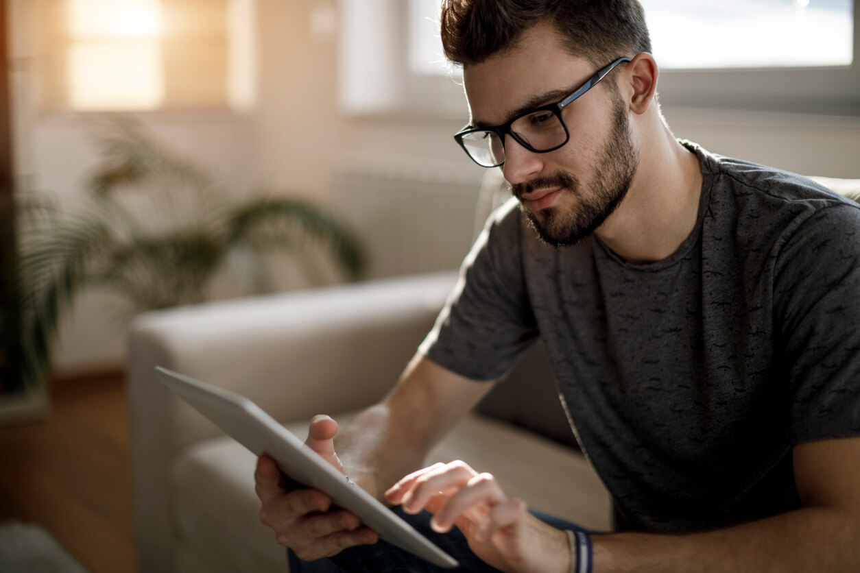 A young man reading Your Brain on Porn on his tablet.