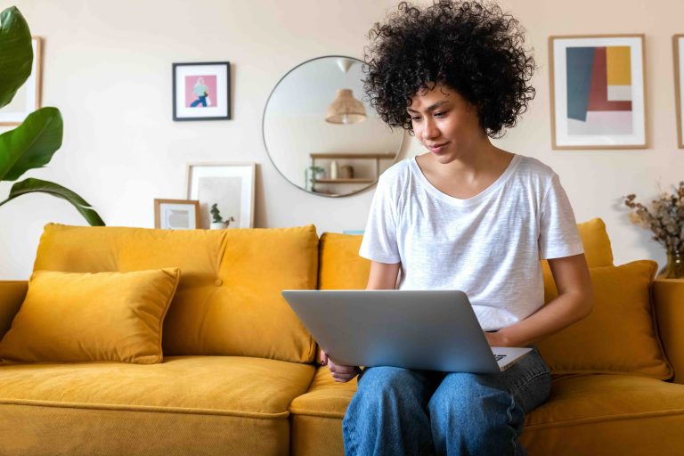 Happy young woman using her computer.