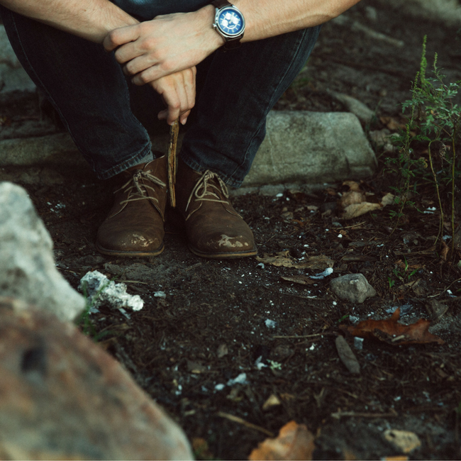 man sitting on rock in woods