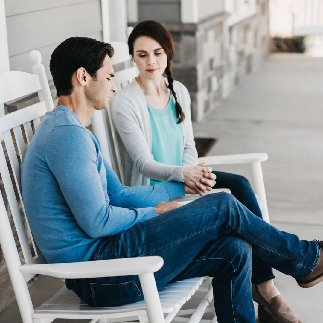 couple holding hands in rocking chairs