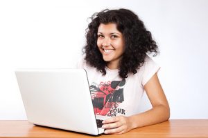 girl smiling in front of laptop