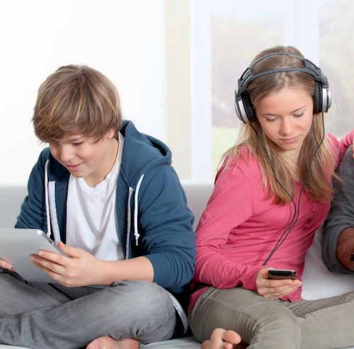 two teens looking at devices