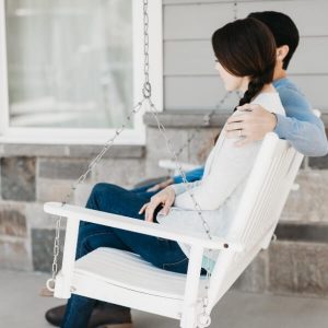 couple talking on porch swing