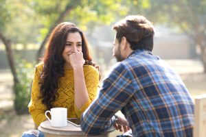 A young couple having coffee in the park.