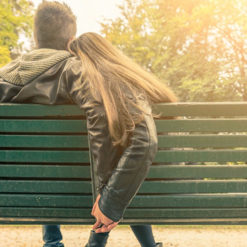 couple sitting on park bench