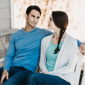 husband and wife sitting on porch swing