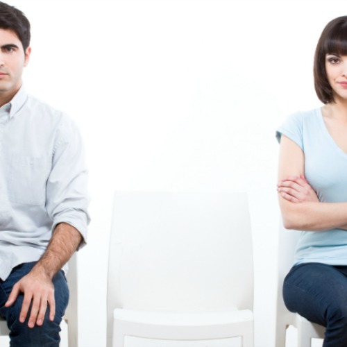 couple sitting with empty chair between them