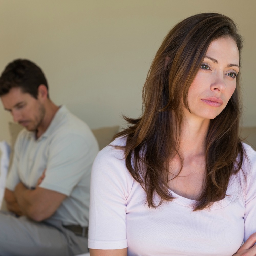 woman sad with frustrated husband behind her