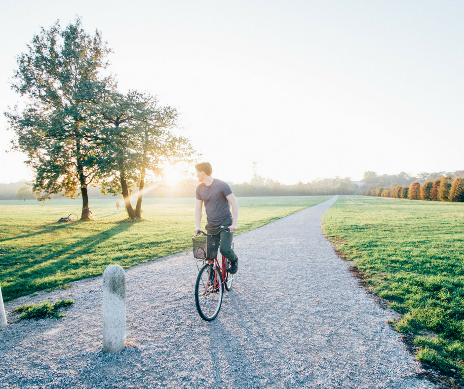man riding bike alone on path