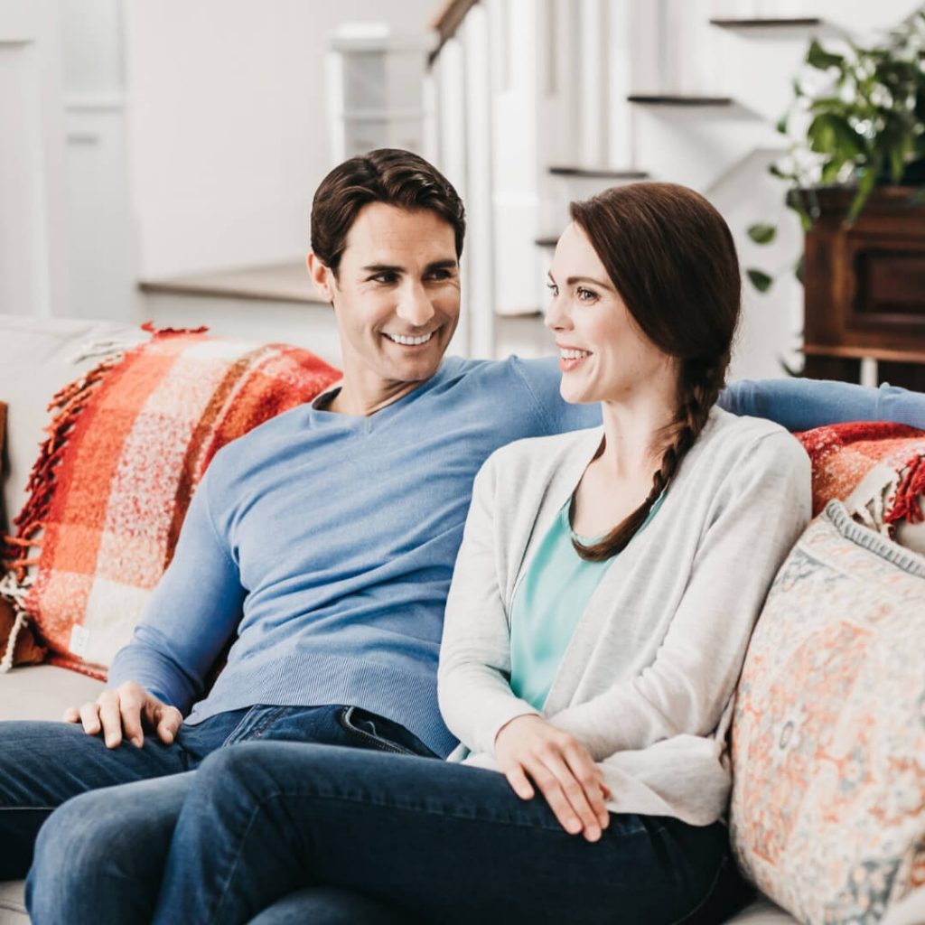couple smiling and talking on couch