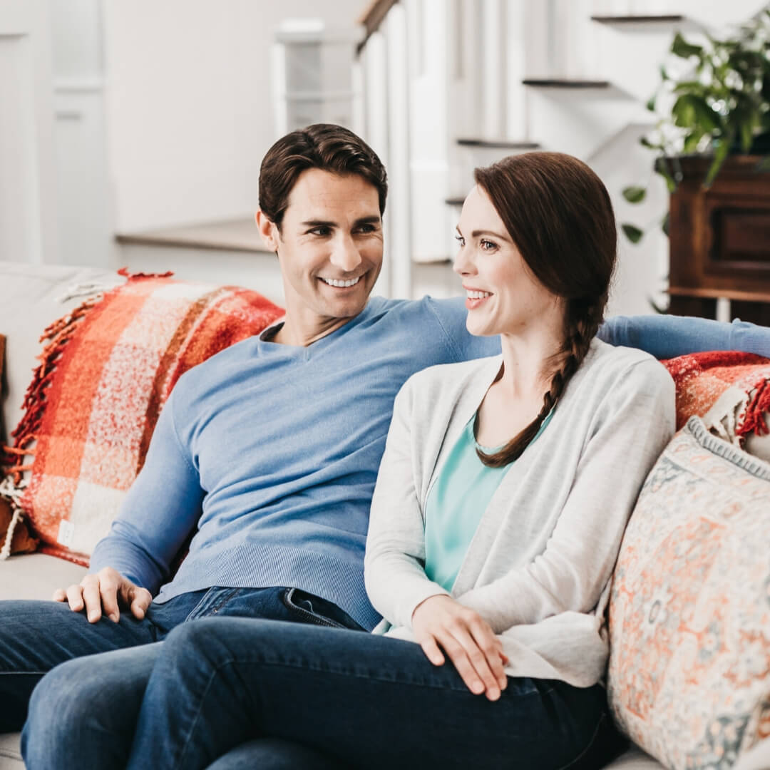 couple smiling and talking on couch