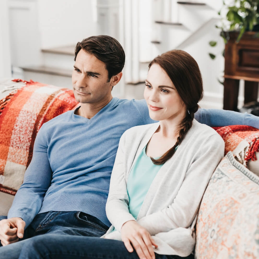 smiling couple watching tv together