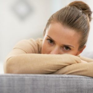 sad woman looking over couch