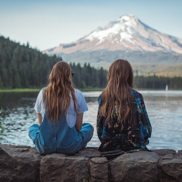 two friends talking by lake