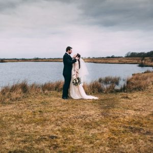 newlywed couple by lake