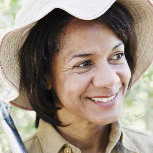 smiling woman with gardening hat on