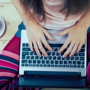 Teen girl sitting with a laptop