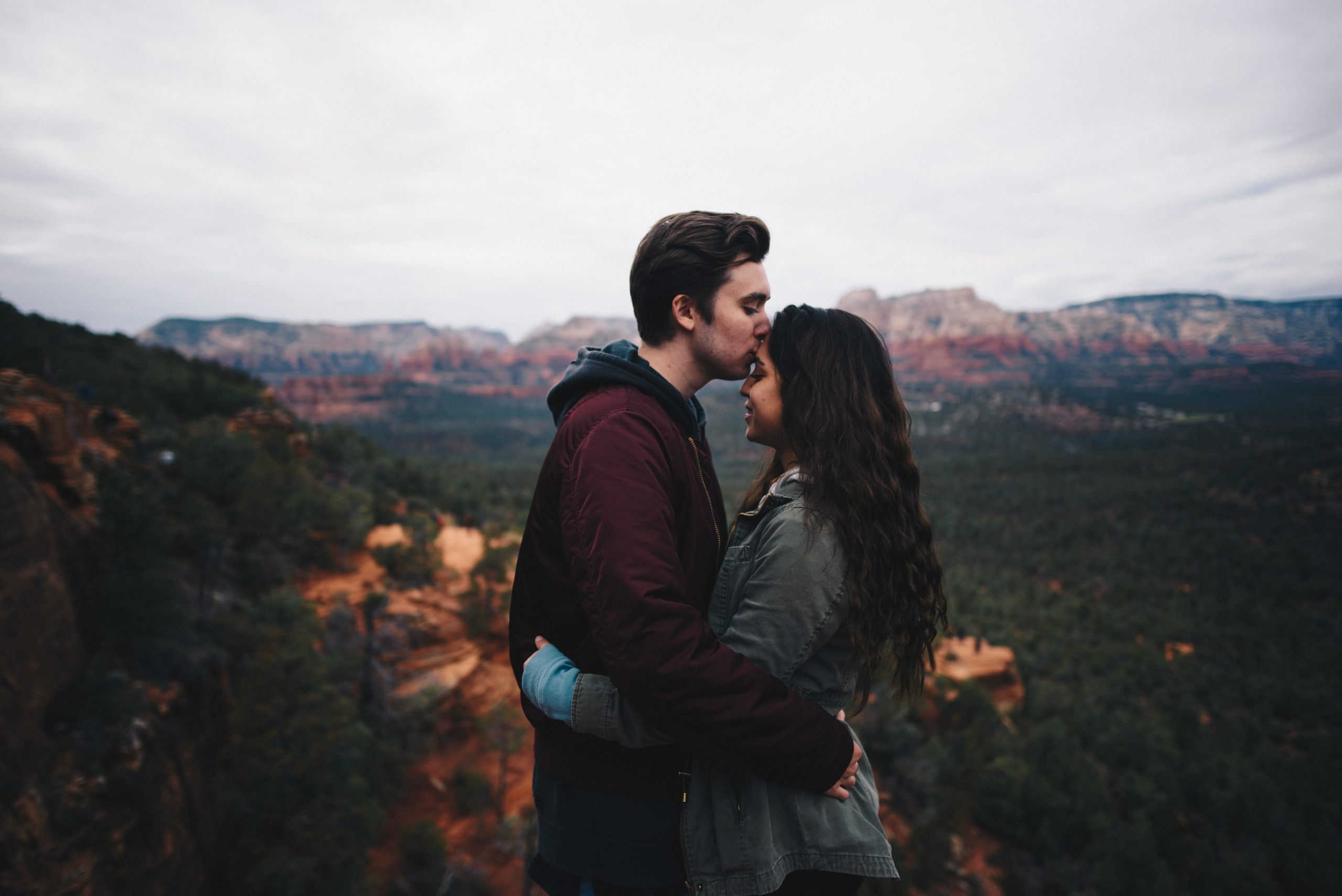young couple hugging by mountain