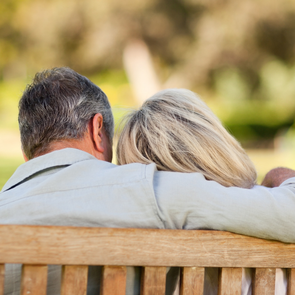 man with arm around wife on bench