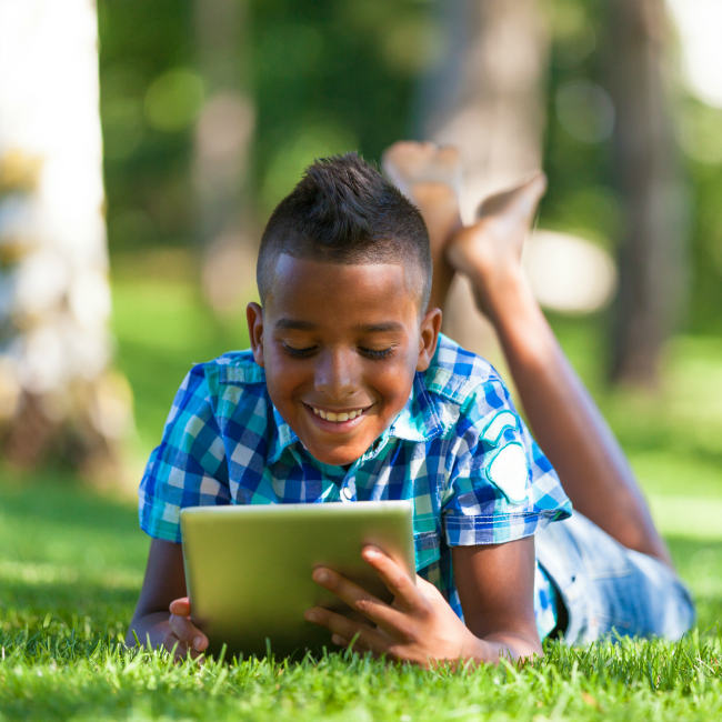 young boy on tablet outside