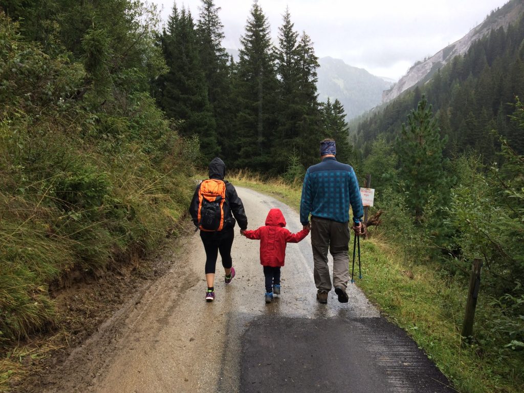 young family walking on mountain path