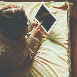 girl on laptop on bed