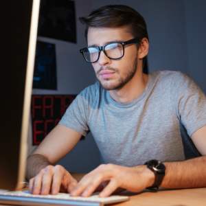 man on computer in dark room