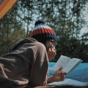 girl reading book outside