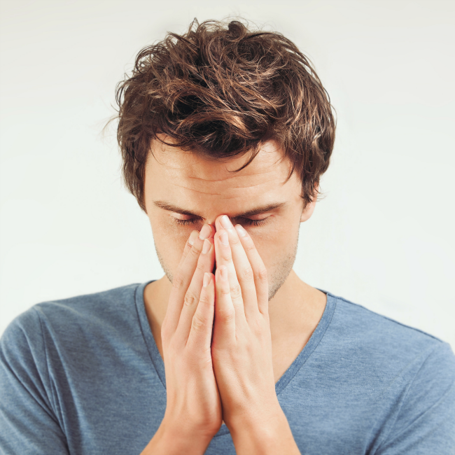 stressed man holding nose
