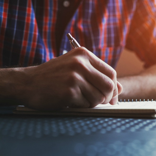 man writing in journal