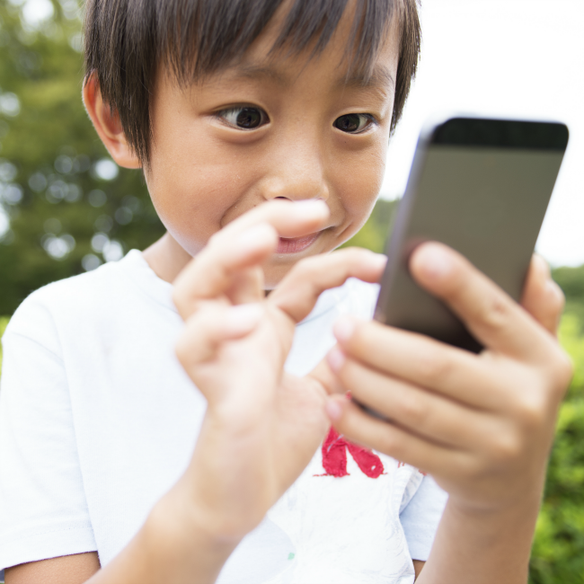 young boy excitedly touching smartphone