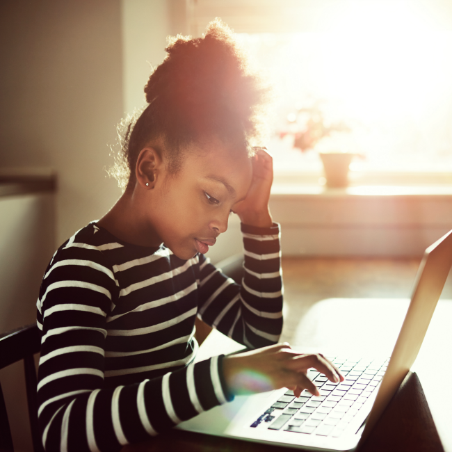 young girl on laptop at kitchen table