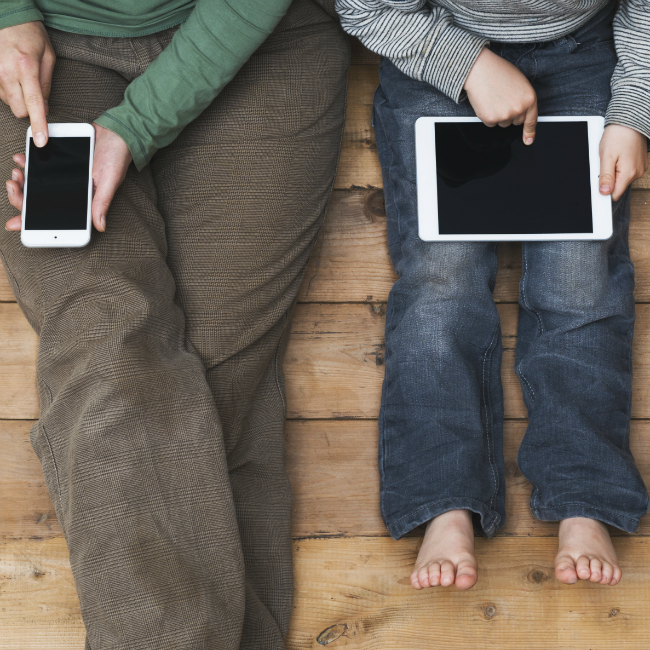 mom on phone, toddler on tablet