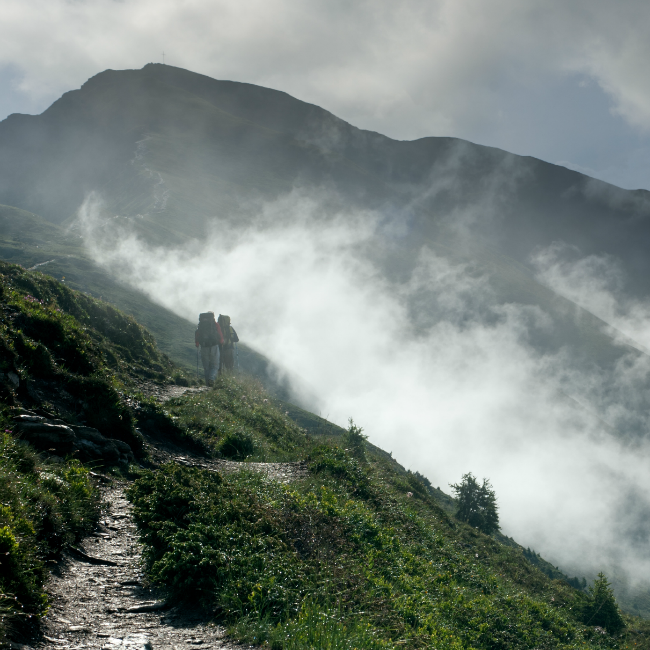 friends walking up misty mountain