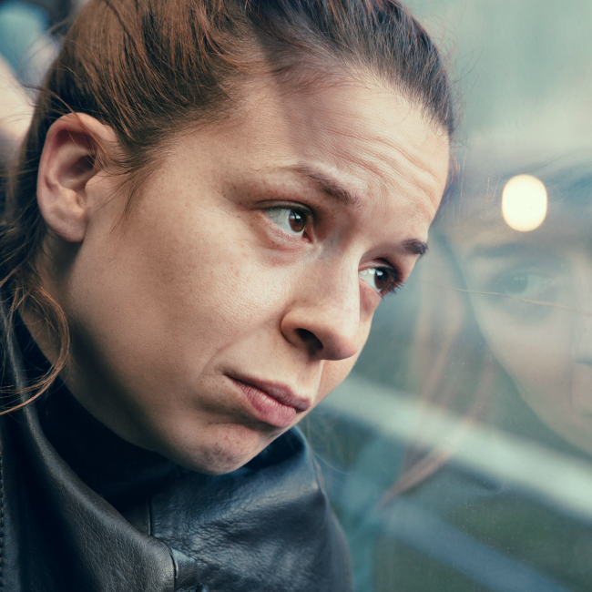 sad woman staring out train window