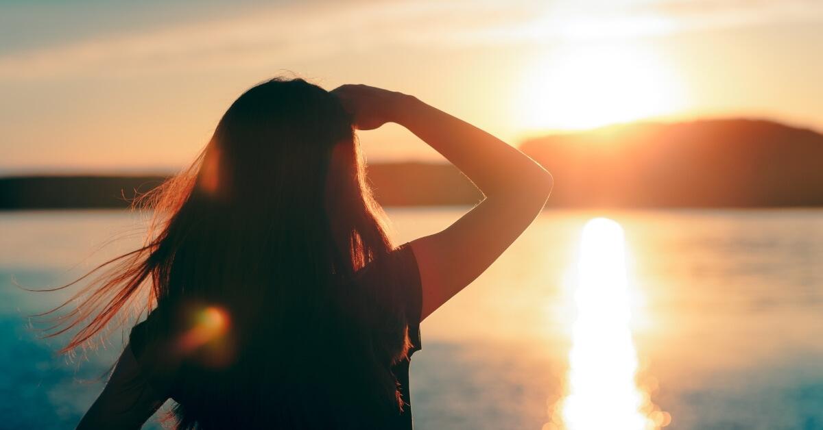 Hopeful Woman Looking at the Sunset by the Sea