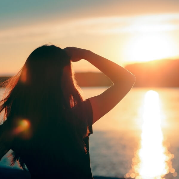 Hopeful Woman Looking at the Sunset by the Sea