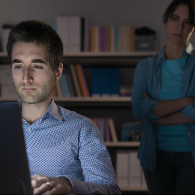 man on computer sad wife behind