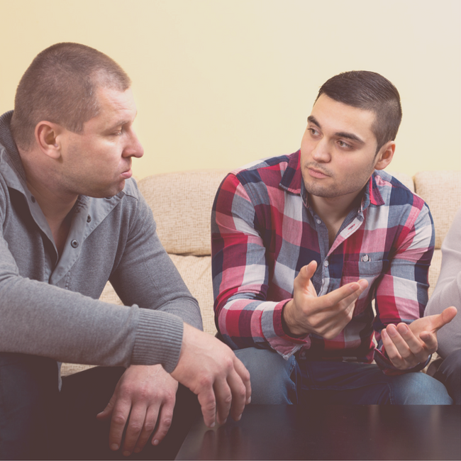 two men talking on couch