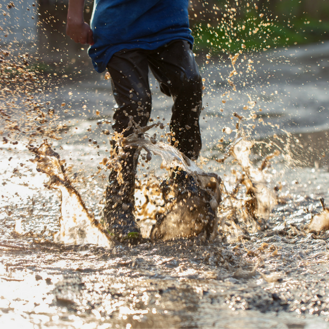 kid jumping in mud