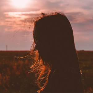 girls hair blowing in field