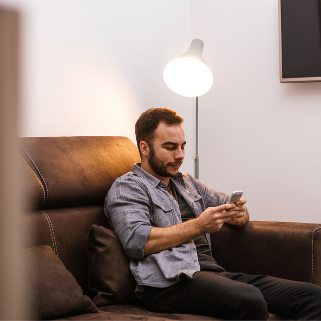man texting on couch