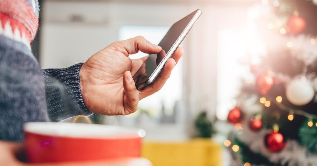 man on phone by christmas tree
