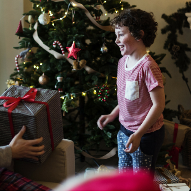 parent handing kid a Christmas present